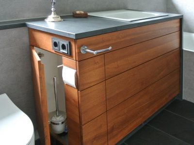Waschtisch in Doussie massiv, geölt. Links zwei schmale Türen für WC Utensilien